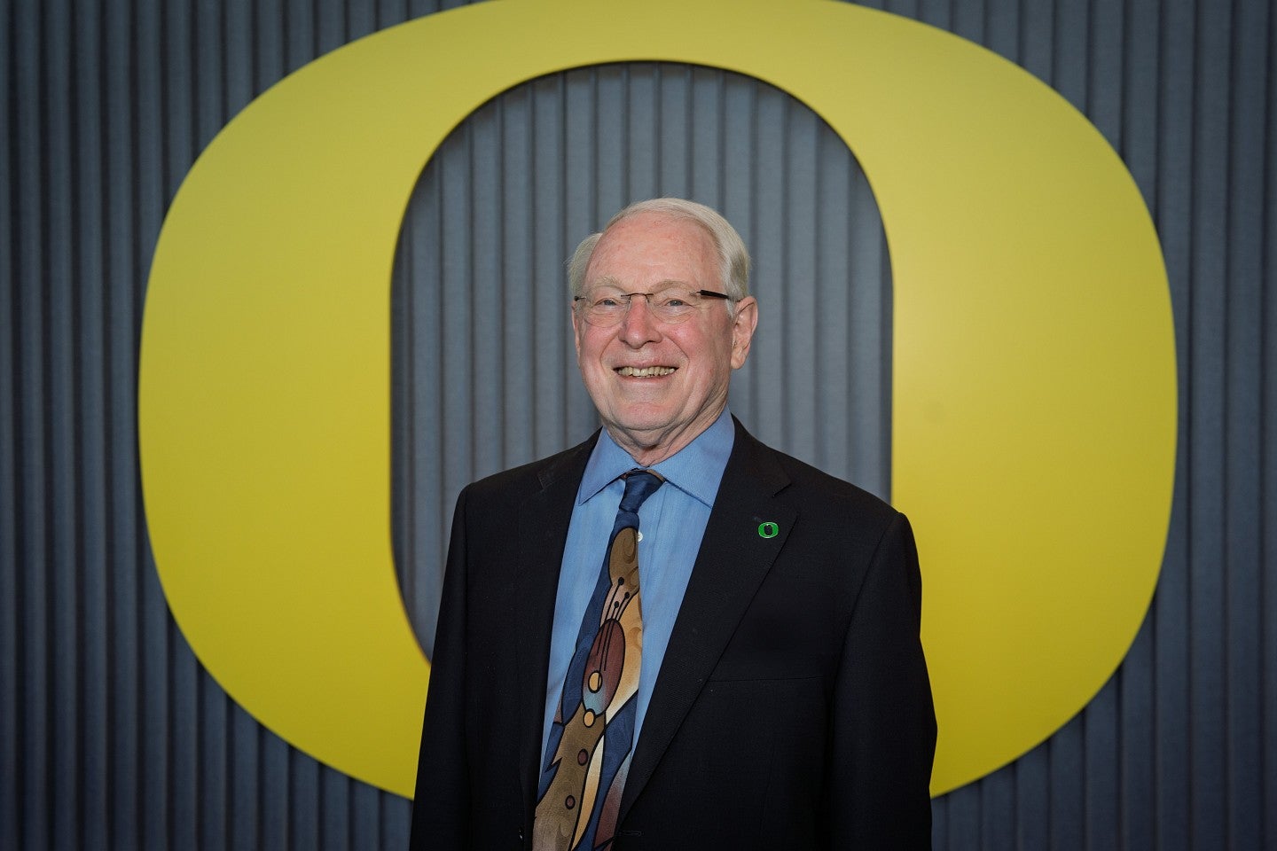 Photograph of Larry Bruton in front of the University of Oregon "O" on the Portland campus. 